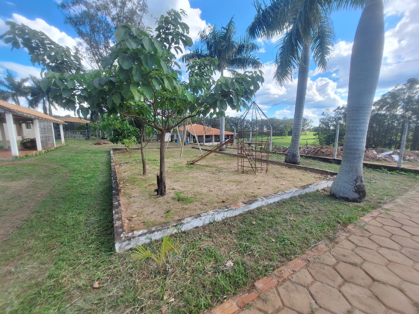 Jardim com parquinho, palmeiras e ampla área verde